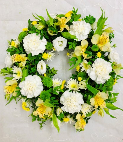 <h2>Extra Large Classic Wreath in Yellow and Cream | Funeral Flowers</h2>
<ul>
<li>Approximate Size W 50cm H 50cm (extra large)</li>
<li>Hand created yellow and cream wreath in fresh flowers</li>
<li>To give you the best we may occasionally need to make substitutes</li>
<li>Funeral Flowers will be delivered at least 2 hours before the funeral</li>
<li>For delivery area coverage see below</li>
</ul>
<br>
<h2>Liverpool Flower Delivery</h2>
<p>We have a wide selection of Funeral Wreaths offered for Liverpool Flower Delivery. Funeral Wreaths can be provided for you in Liverpool, Merseyside and we can organize Funeral flower deliveries for you nationwide. Funeral Flowers can be delivered to the Funeral directors or a house address. They can not be delivered to the crematorium or the church.</p>
<br>
<h2>Flower Delivery Coverage</h2>
<p>Our shop delivers funeral flowers to the following Liverpool postcodes L1 L2 L3 L4 L5 L6 L7 L8 L11 L12 L13 L14 L15 L16 L17 L18 L19 L24 L25 L26 L27 L36 L70 If your order is for an area outside of these we can organise delivery for you through our network of florists. We will ask them to make as close as possible to the image but because of the difference in stock and sundry items it may not be exact.</p>
<br>
<h2>Liverpool Funeral Flowers | Wreaths</h2>
<p>This striking wreath-shaped design has been loving handcrafted by our florists and features a classic selection of flowers including irises, carnations and spray chrysanthemums in yellows and creams are nestled into this traditional circular extra large wreath.</p>
<br>
<p>A funeral wreath is flowers arranged in a circular shape with a hole in the centre. This circular shape symbolises the circle of life or eternal life. They are suitable for sending directly to a funeral whether you are family or a friend.</p>
<br>
<p>Contents of 16 inch oasis ring: 9 Iris, 11 Cream Carnations, 6 Cream Spray Chrysanthemums, 7 Cream Spray Carnations, 3 Yellow Solidago, 6 Green Spray Chrysanthemums and mixed Foliage.</p>
<br>
<h2>Best Florist in Liverpool</h2>
<p>Trust Award-winning Liverpool Florist, Booker Flowers and Gifts, to deliver funeral flowers fitting for the occasion delivered in Liverpool, Merseyside and beyond. Our funeral flowers are handcrafted by our team of professional fully qualified who not only lovingly hand make our designs but hand-deliver them, ensuring all our customers are delighted with their flowers. Booker Flowers and Gifts your local Liverpool Flower shop.</p>
<br>
<p><em>Jane Catherine and Family - Review by Post - Funeral Florist Liverpool</em></p>
<br>
<p><em>Thank you so much for the amazing flowers you arranged for our mum she would have loved them. Love Jane, Catherine and family</em></p>
<br>